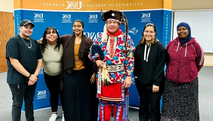 来自FNSA小组的学生与穿着传统印第安人服装的演讲者合影